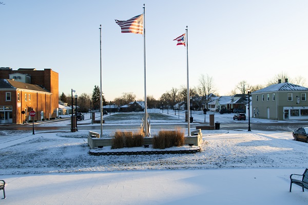 Three flagpoles with flags flying on the right and center poles